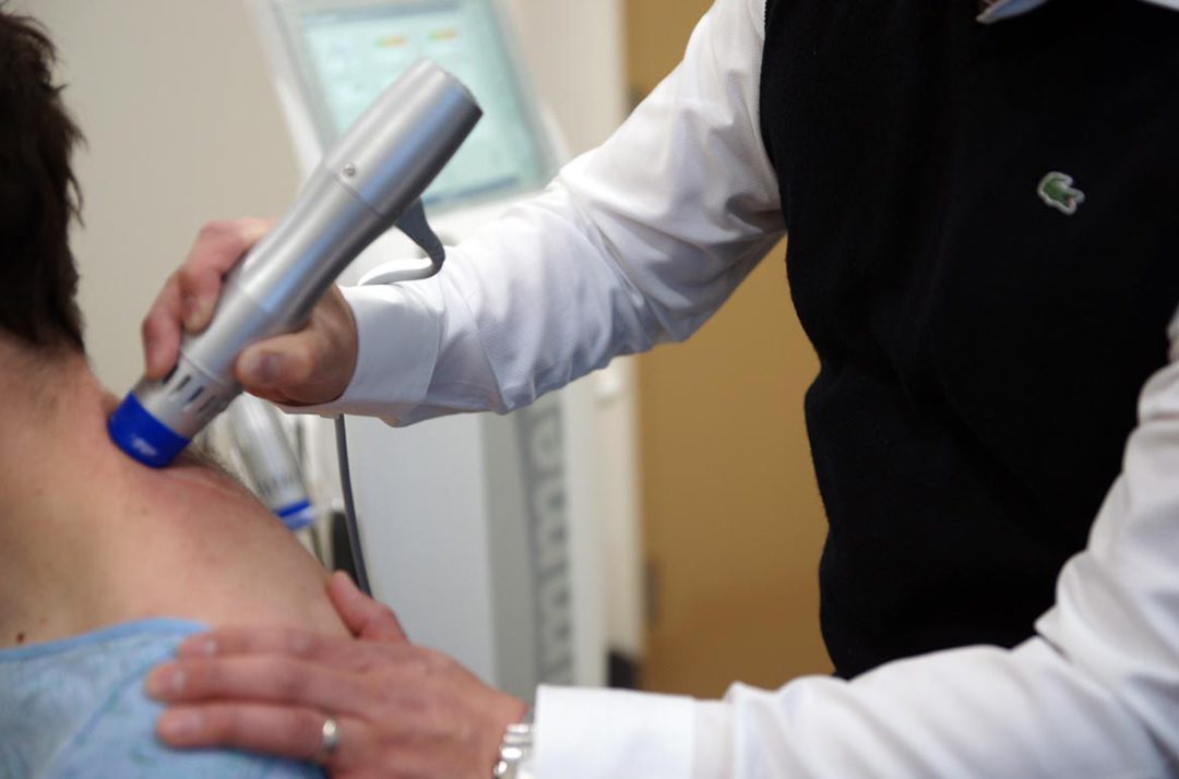 Masseur doing anti-cellulite massage to client in spa beauty salon using oil Laser treatment for neck